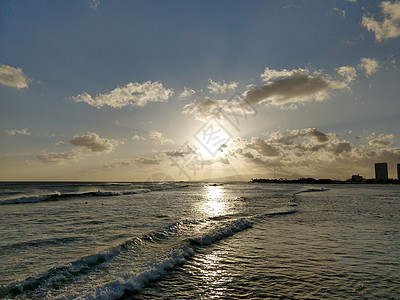 日落在云中 从海洋向海滩的海浪横行图片
