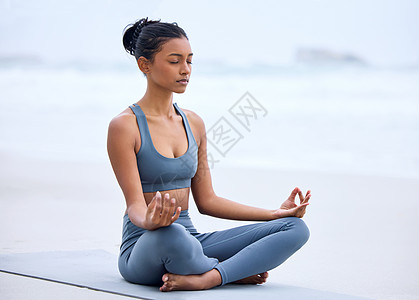 在沙滩上练瑜伽时 一位迷人的年轻女子沉浸在冥想中的一整段镜头图片