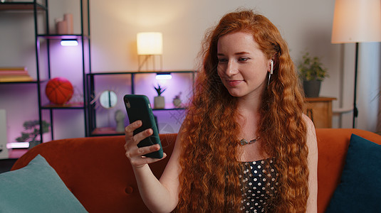 女孩与手机红发女人享受智能电话聊天 手机在家与朋友交谈的爱打情话雀斑说话女性成功讨论自由职业者企业家女士快乐耳机背景