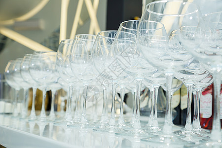 餐桌设置 许多玻璃透明的杯子用于葡萄酒和香槟团体桌子酒杯餐厅宴会柜台液体商业派对饮料图片