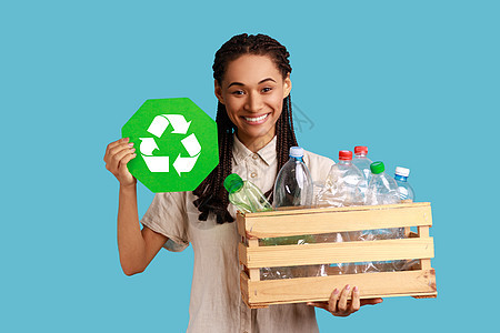 微笑的妇女拿着塑料瓶 回收 废物分类和可持续性的盒子 装满了塑料瓶图片