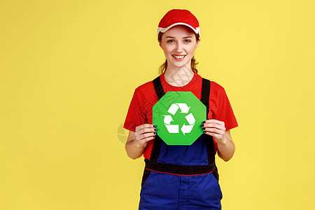 微笑快乐的女工站着 拿着回收标志 满怀绿色思想图片