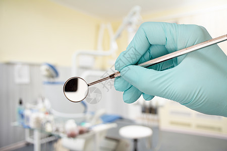 牙医用嘴镜戴手套的手图片