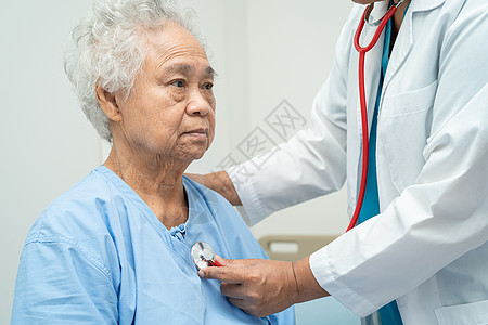 老年护理医生坐在护理医院病房的床上 用听诊器检查老年或老年老妇人的病人 健康强健的医疗理念护士医院男性房间疾病手术家庭外科诊所退休背景