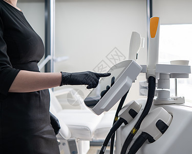 医生美容学家使用触摸屏对光复发装置进行调整 以适应感应屏病人身体药品工具皮肤诊所服务女性机器女士图片