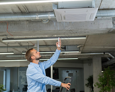 白胡子男正在修理办公室的空调机 他叫天花板工程师承包商男性空调修理工服务职业测量工作技术员高清图片素材
