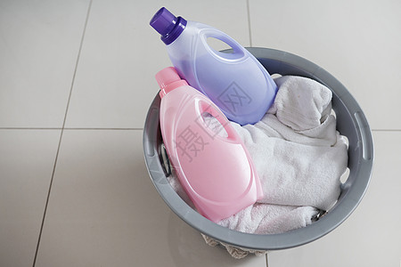 衣物柔顺剂 适合那些洗衣日 让您倍感舒适 一个装满干净衣物和两瓶织物柔软剂的洗衣篮的高角度拍摄图片