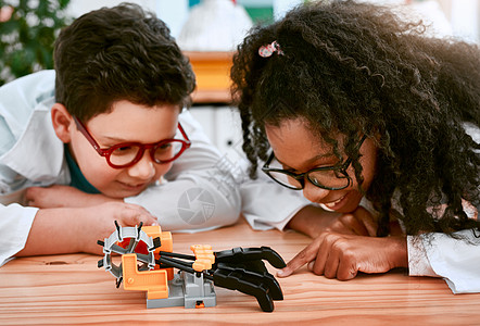 让我们看看它是否有效 一个可爱的小男孩和女孩在学校的科学课上建造机器人图片