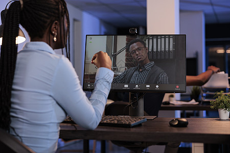 青年雇员在计算机上使用在线视频呼叫电话会议员工工人电脑屏幕日落电话会议公司讲话推介会人士图片