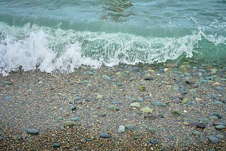 海滨 海边有碎石 沙滩上湿海岩和宁静的海浪海洋环境力量飞溅泡沫海滩海景支撑蓝色荒野图片