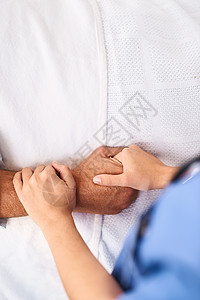 我们永远不会放手 医疗诊所内一名医生握着一只面目全非的人的手的特写图片