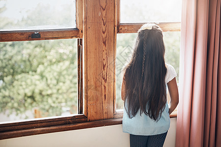在一个巨大的世界里等待她的是什么 一个年轻女孩从家里的窗外看出来的回视镜头图片