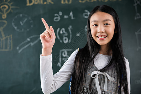 亚洲女学生穿制服 背着背包在课堂上用指头指黑板教育学习孩子们童年班级孩子学校微笑学生绿色图片