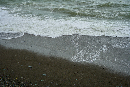 海滨 海边有碎石 沙滩上湿海岩和宁静的海浪天气海岸海洋支撑冲击波戏剧性海滩荒野潮汐热带图片