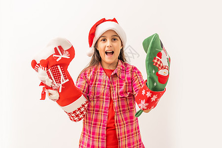 可爱笑笑的小孩女孩 穿着红礼服检查她的圣诞丝袜婴儿传统短袜快乐喜悦女孩季节眼睛帽子展示图片