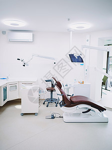 现代牙科办公室 棕色皮椅和牙医用白光医疗器使用的其他饰品外科医院座位技术员单元援助卫生职场房间展示背景图片