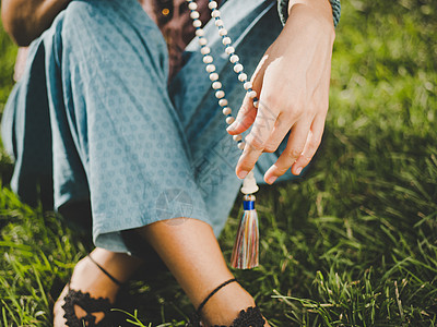 女人 点燃的手特写 数着 Malas 在咒语冥想期间用来计数的木珠串 佛教 夏天坐在公园里的女孩女士上帝瑜伽姿势专注上师孩子精神图片