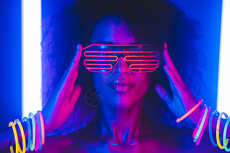 彩色光辉的派对上的非洲美女网络式肖像 夜总会 未来服装和奈子眼镜 青少年 动物Z一代 在晚宴中 女明星Z世代卷曲广告女性女孩工作图片