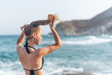 年轻女人在海滩上做马尾辫图片