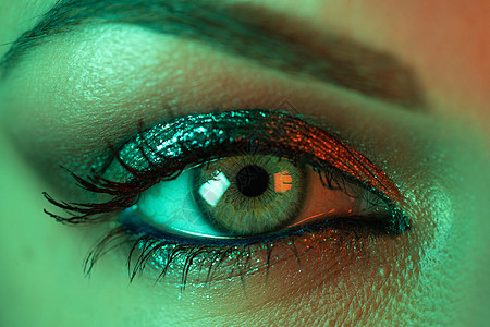 女性眼睛虹膜在霓虹灯下的极端特写 美丽的妆容 闪闪发光的阴影和假睫毛的女人 女孩绿眼睛 夜生活 夜总会的概念艺术皮肤睫毛瞳孔眼球图片