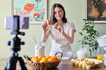 在厨房做橙子煎煎饼的 家庭主餐店女性社交博主互联网追随者橙子烹饪技术青少年媒体背景