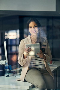准备晚班 一个年轻的女商务人士在深夜工作时使用数字平板电脑图片