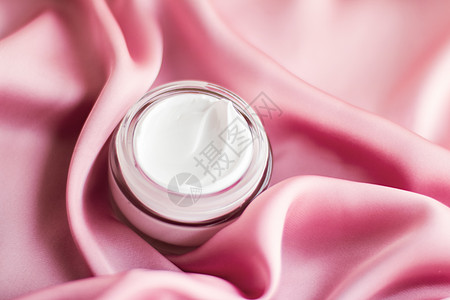 柔软粉色丝绸上的奢华面霜淇淋罐润肤奶油水疗乳液产品展示保湿卫生美容护理图片