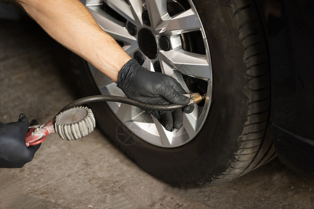 使用气压计检查汽车轮胎压力 给汽车轮胎充气的技工 汽车车轮的气体泵送 汽车轮胎充气图片