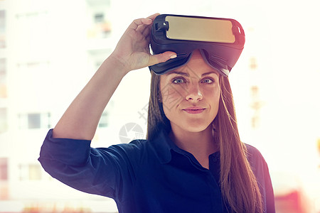 掌控自己的未来 一位在办公室里戴着 VR 耳机的年轻女商务人士的画像图片