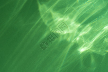 绿色墙壁上的焦散效果光折射覆盖照片模型 模糊的太阳光线通过带阴影的玻璃棱镜折射 水面上的抽象自然光折射轮廓背景图片