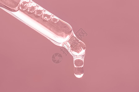 粉红色滴管特写 落下的滴特写 美容护肤品 带精油的吸管 带肽的血清 粉红色背景的透明质酸 自理图片