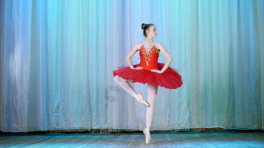 年轻芭蕾舞者穿红色芭蕾舞裙和指尖鞋 跳优雅的芭蕾运动 Pas courru 巡回演出fouette图片