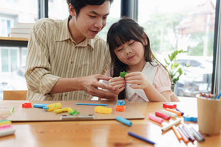 可爱的小女孩和父亲玩多姿多彩的可塑塑料 手工制作技能培训婴儿精神科医生手指闲暇训练心理学学习童年玩具图片