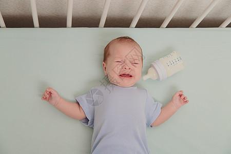 一个饥饿的婴儿在婴儿床里哭泣 婴儿哭 孩子的情绪 出牙时疼痛 一个饥饿的孩子 儿童肠绞痛家庭寝具保健卧室送货皮肤床头女孩摇篮卫生图片