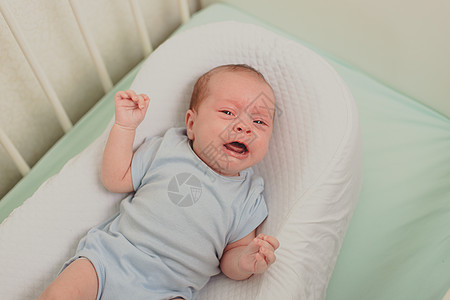 一个饥饿的婴儿在婴儿床里哭泣 婴儿哭 孩子的情绪 出牙时疼痛 一个饥饿的孩子 儿童肠绞痛家庭皮肤生活卧室童年房间睡眠毯子寝具床单图片
