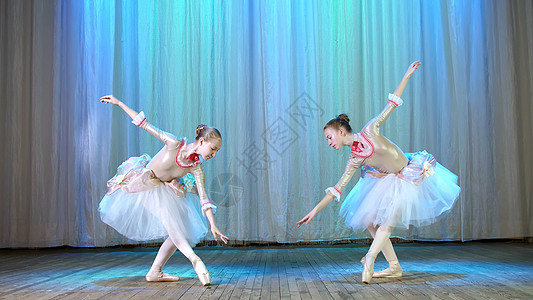 芭蕾排练 在旧剧院大厅的舞台上 穿着优雅连衣裙和足尖鞋的年轻芭蕾舞演员 优雅地跳着某些芭蕾舞动作 传球 风景优美的鞠躬姿势地面艺图片