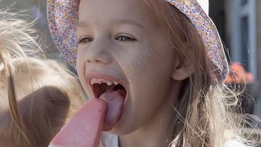 特写肖像女孩喜欢美味的冰淇淋甜筒 孩子吃西瓜冰棒 家庭花园里的孩子们的兄弟姐妹零食糖果 暑假炎热的天气晴天 童年 食品糖果朋友情图片