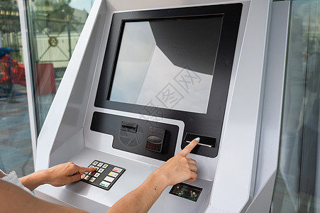 机器手白种女人从机器里买票卡片铁路银行卡服务电脑门票公共汽车自助消费者信用背景