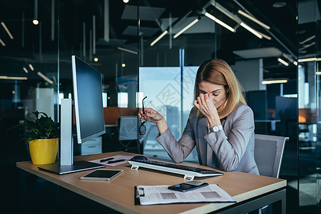 在现代办公室做电脑工作的 疲劳的女商务人士 眼痛图片