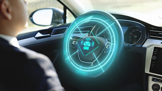 车辆开始自动驾驶 一名驾驶未来派汽车的男子在增强现实全息图 HUD 上激活自动驾驶仪 坐在自动驾驶零排放汽车里的商务人士图片