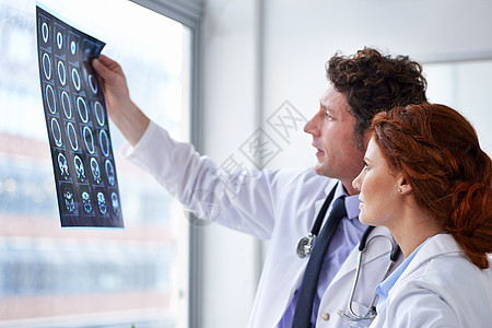 诊断结果看起来不错 两个医生在看脑部扫瞄图片