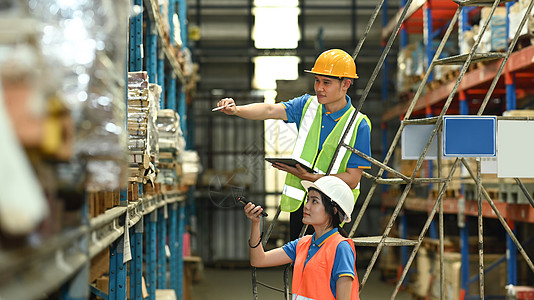 仓库工作人员在大型仓库的货架上用条形码扫描仪检查库存箱图片