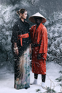 时装幻想 一个男人和女人穿着东方式衣服 在雪林里时装照的镜头图片
