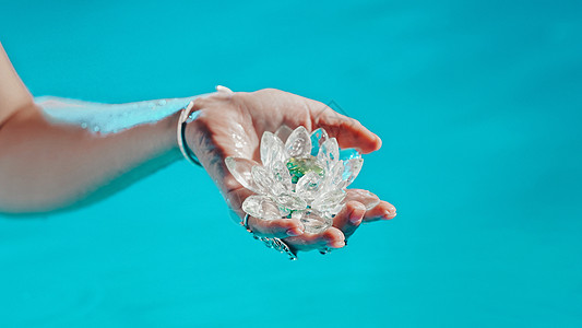 拿着易碎的莲花的妇女 清澈的水珠从水晶中滴落 宗教 昆达里尼 冥想 脉轮 精神内心世界的概念矿物手工女性椭圆形女士玻璃热带游泳池图片
