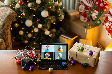 在圣诞快乐餐桌假期背景下 通过远程聊天数字平板电脑屏幕与孩子进行家庭视频通话 圣诞节在线虚拟家庭聚会庆祝活动 新年快乐视频通话隔图片
