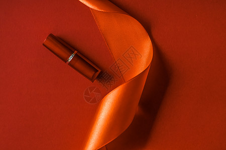 橙色假日背景 化妆和化妆品板 用于美容品牌产品设计的奢华口红和丝带丝绸魅力光泽度展示推广美丽橙子老板季节生物礼物图片