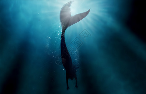 美人鱼在深蓝色大海中孤独游泳的剪影照片 - 此图像上的所有设计均由专业团队为这张照片拍摄从头开始创建图片