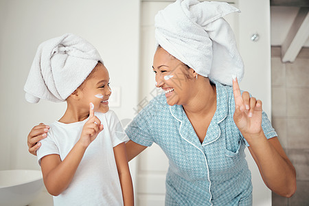 淋浴 清洁和卫生后 家中浴室内的母亲 儿童和护肤面霜化妆品 快乐的妈妈 微笑的女孩和健康的保湿霜 美容液和身体磨砂膏图片