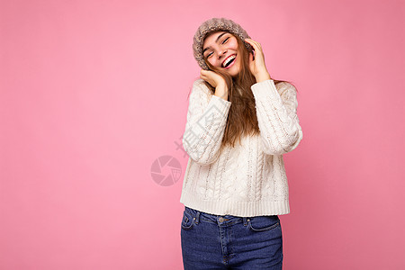 美丽 积极 快乐的黑发年轻女性 与色彩缤纷的背景墙隔绝 穿着休闲时尚的衣服 看着镜头 感觉真挚深色粉色幸福白毛衣灰帽帽子背景图片