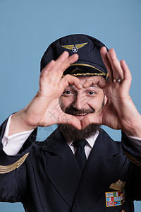 微笑驾驶机飞行员展示心脏形状的爱符号图片